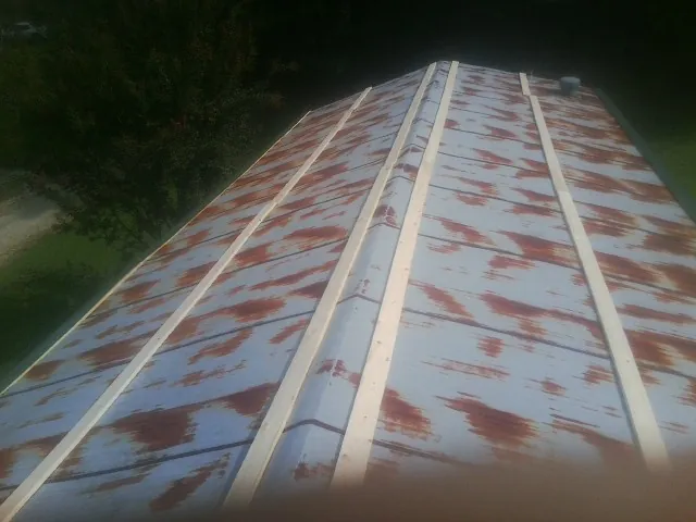 Rusted metal roof panels with new wood purlins before replacement — Storm Damage Roof Repair in Sharon Springs by Roofing Brothers