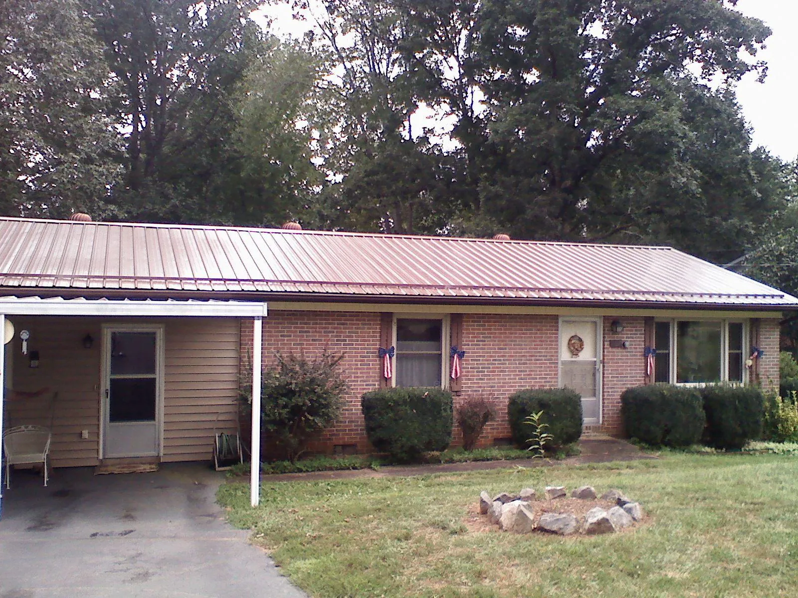 Bronze metal roof and carport on a brick ranch home — Roof Repair work by our crew in Sharon Springs